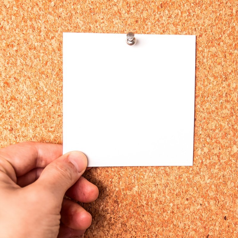 A Hand Pinning A Blank White Paper On A Corkboard Corkboard
