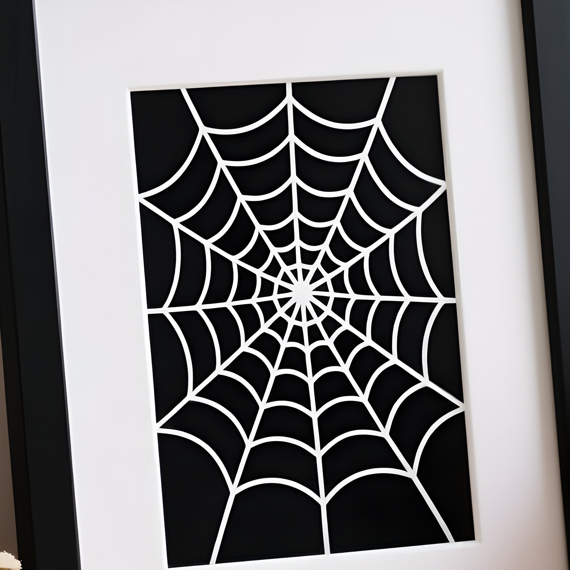 A Neatly Arranged Desk Setup With A Spider Web Picture Frame As - Full Resolution Quality Preview
