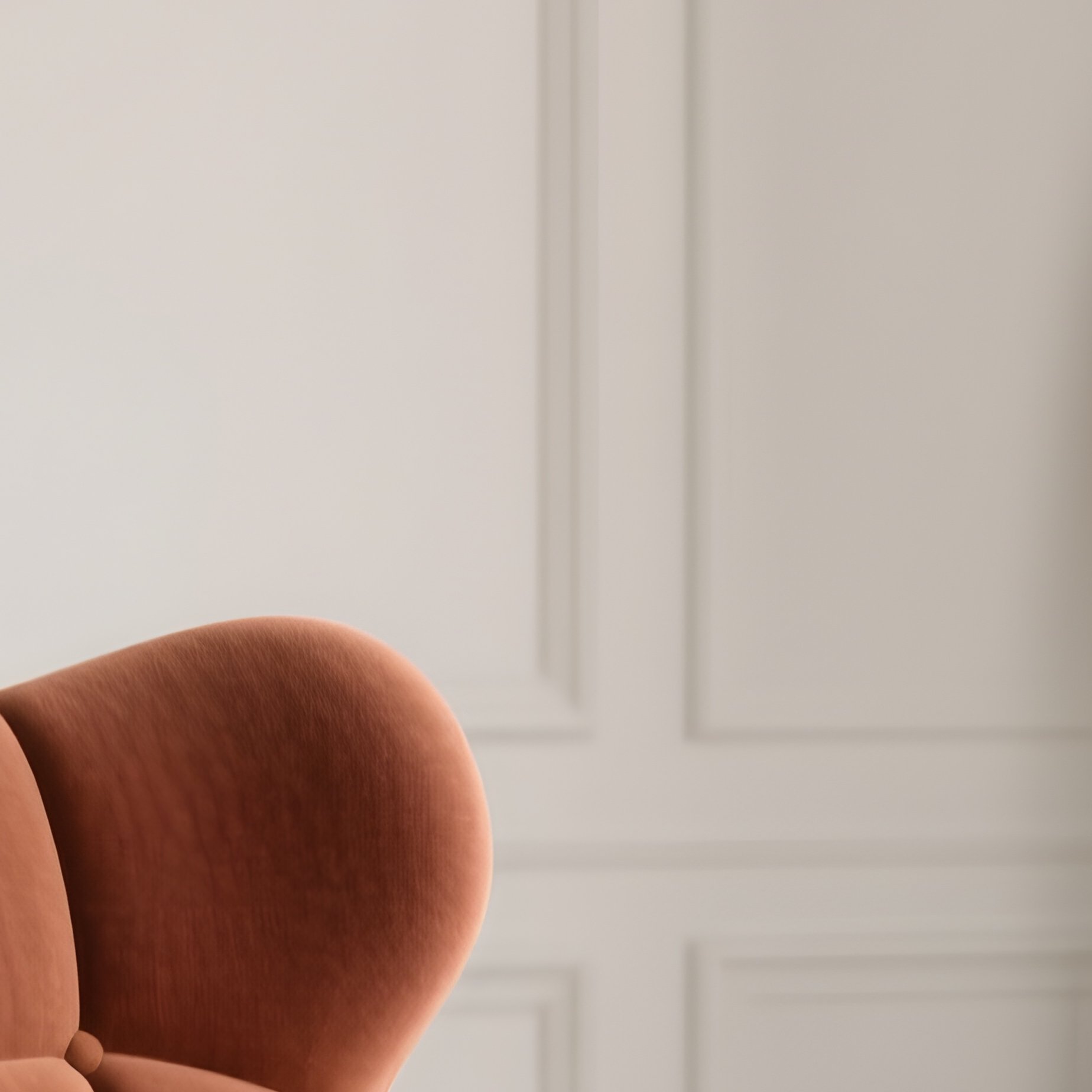 A Refined Living Room With A Sculptural Accent Chair In Terracotta Fabric, Paired With A Travertine Side Table And Neutral Toned Walls - Full Resolution Quality Preview