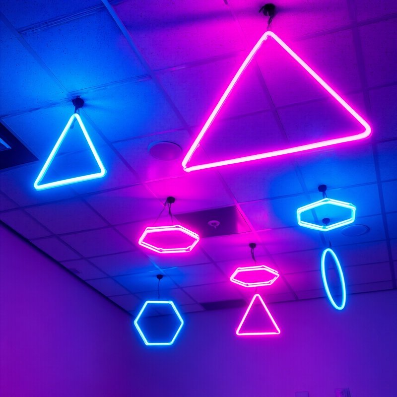 Ceiling With Acoustic Tiles And Suspended Geometric Neon Lights