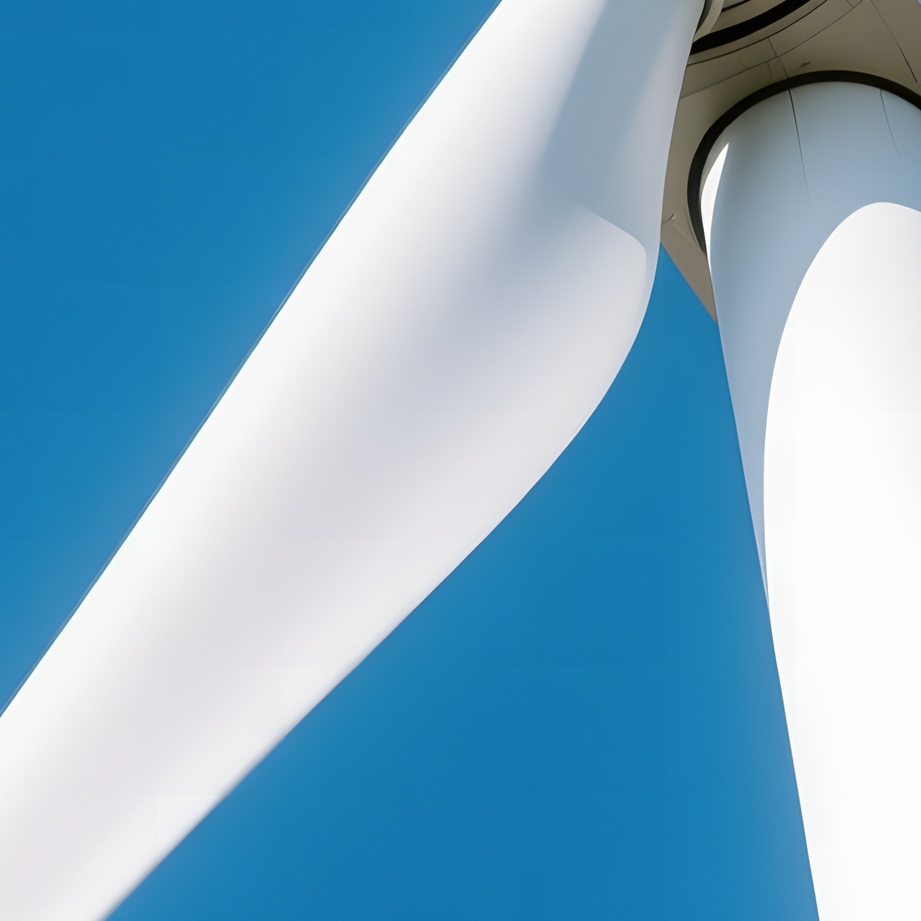 Wind Turbine Blade: A Dizzying Perspective Looking Up From The Base Of A Giant White Wind Turbine. The Blade Swoops Down, Cutting Through The Blue Sky. - Full Resolution Quality Preview